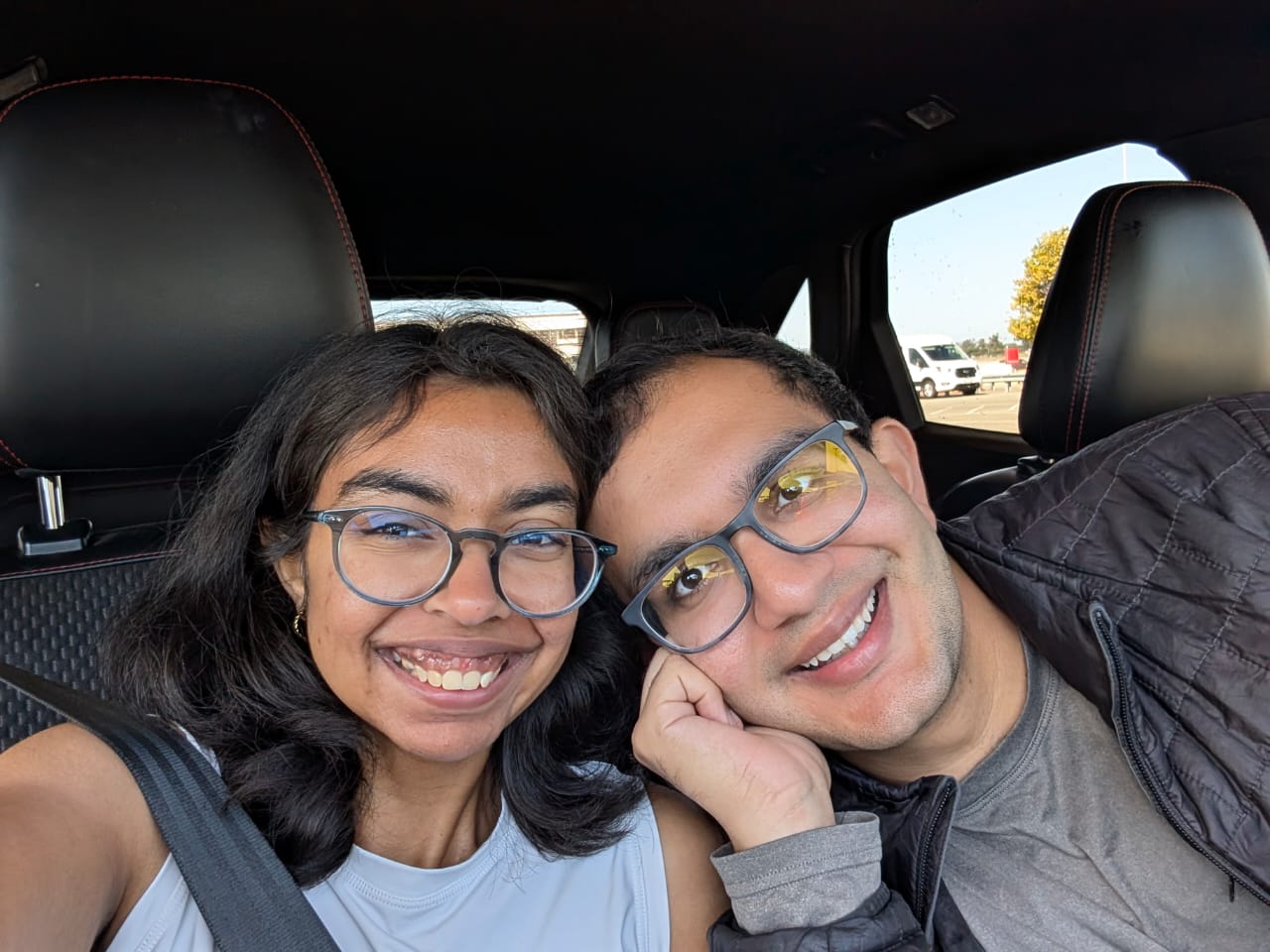 Yash and Sancia smiling in a car